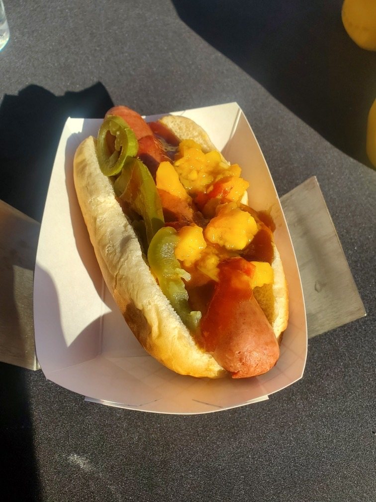 A loaded Glizzy — quarter-pound all-beef dog with peppers, cheese, and mustard